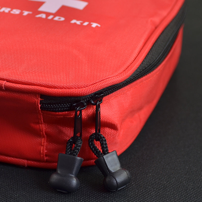 The eprolo 25-Piece Compact First Aid Kit, featuring a red exterior with a white cross and FIRST AID KIT, offers essentials for outdoor emergencies. Two black zipper pulls peek from its partially unzipped form, making it perfect for hiking or car trips.