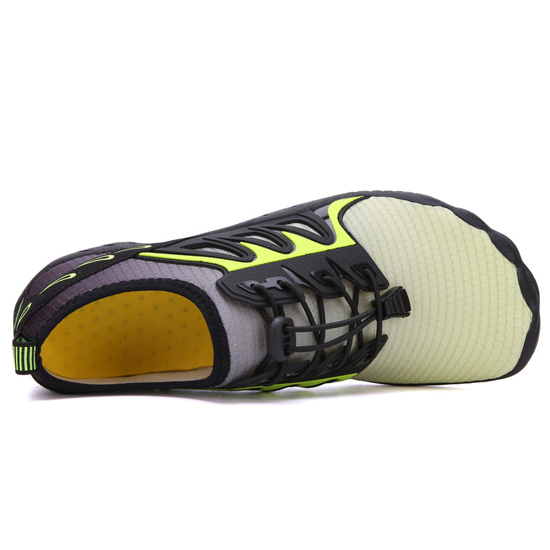 The Modalyst Barefoot Quick Dry Beach Pool Aqua Shoes - Mens, feature a minimalist black design with neon green accents and textured beige soles. Ideal for beach activities, the slip-on shoes include black laces and a heel pull-tab for quick drying, all presented against a white background.