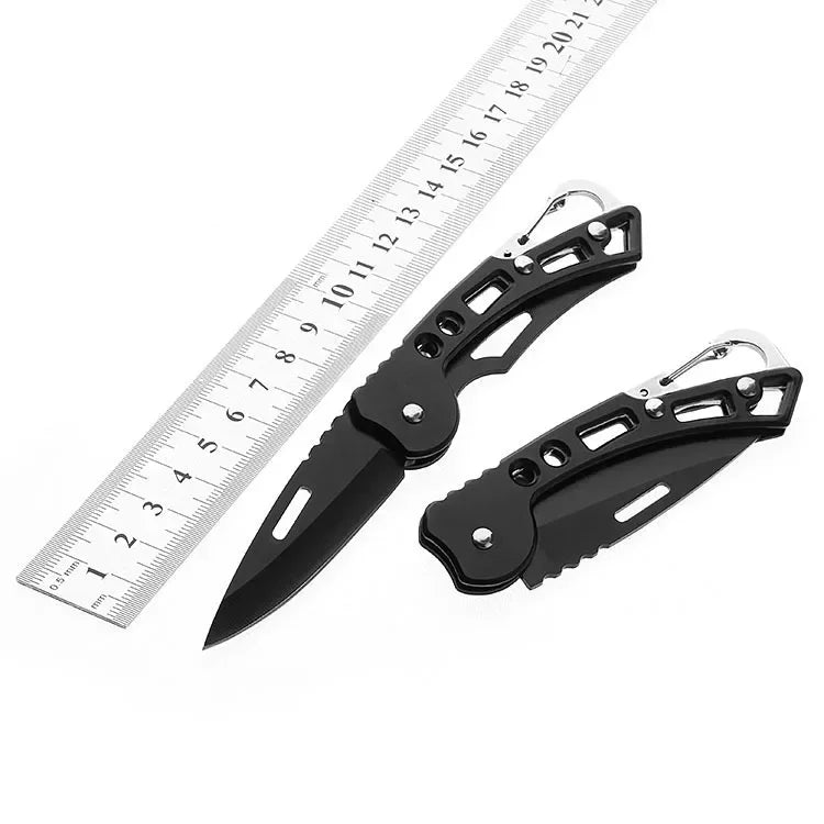 A Ten Essentials Folding Stainless Steel Pocket Knife–Portable Survival & Outdoor Tool lies open with a closed one on a white background. A silver ruler with centimeter markings is placed alongside to indicate size.