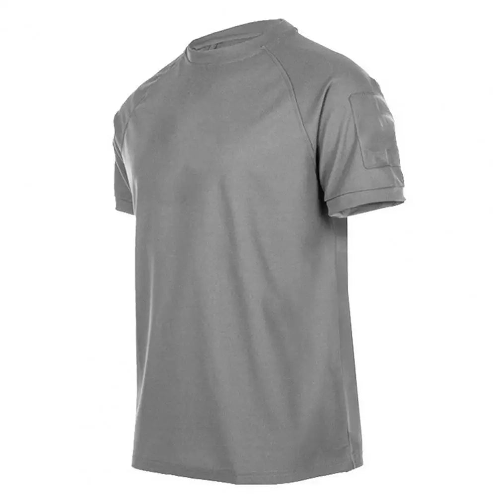 Ten Essentials Men’s Quick-Dry Military T-Shirt, shown on a white background, is gray with short sleeves, a crew neck, and an upper left sleeve pocket. It features lightweight, breathable, and moisture-wicking fabric.