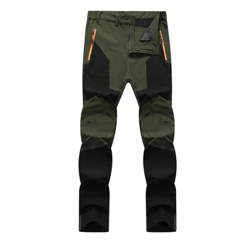 Ten Essentials olive green and black Men’s Quick-Dry Hiking Pants feature orange zippers, reinforced knees, and multiple pockets. Made with water-resistant stretch fabric, they provide UV protection for safety outdoors.