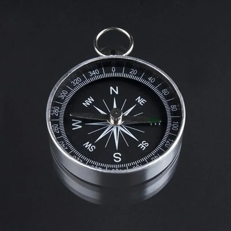 The Portable Aluminum Emergency Compass by Ten Essentials is a lightweight survival navigation tool featuring a silver aluminum frame, black face, fluorescent pointers for visibility, cardinal directions with degree markings, and a reliable north-pointing needle—a crucial outdoor accessory.