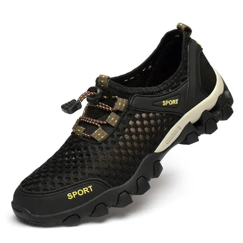 Ten Essentials Men’s Breathable Mesh Sneakers in black and gold feature SPORT on the side, a rugged non-slip rubber sole with large grips, a quick-lace system for easy adjustment, and a sturdy heel loop for convenience. Designed as lightweight shoes for hiking or casual wear.
