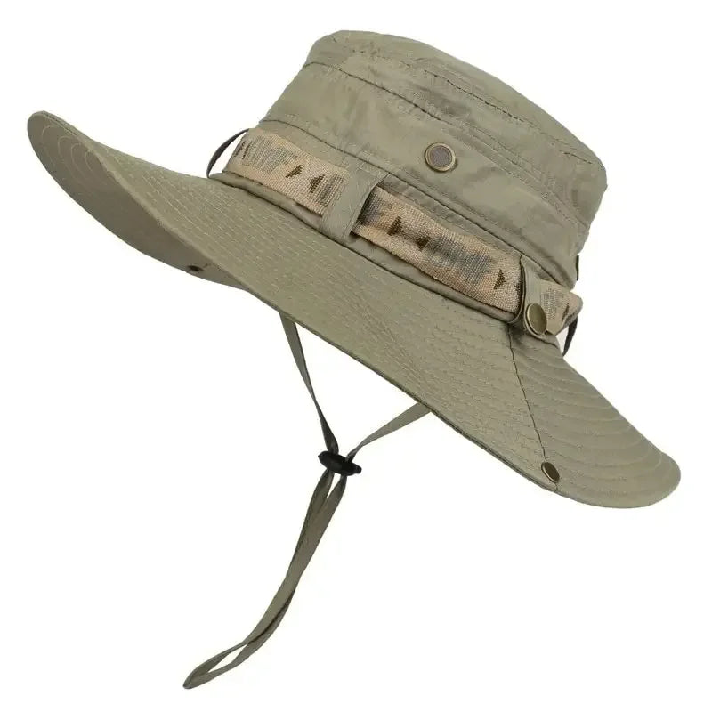 This Mens Summer Bucket Hat by Ten Essentials is a tan, wide-brimmed safari and hiking cap with an adjustable chin strap and crown band. It features breathable mesh panels, metal ventilation grommets, and UV protection for outdoor activities.