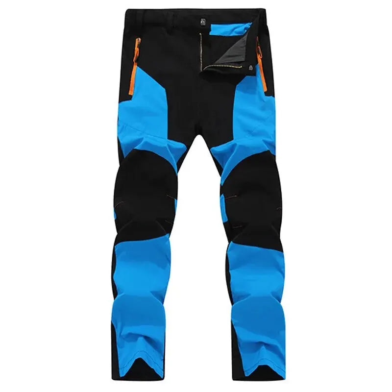 Ten Essentials Men’s Quick-Dry Hiking Pants feature UV protection and water-resistant, ultra-stretch fabric. Available in black and blue with orange zippered pockets, they boast reinforced knees and a slim fit for enhanced comfort during any adventure.