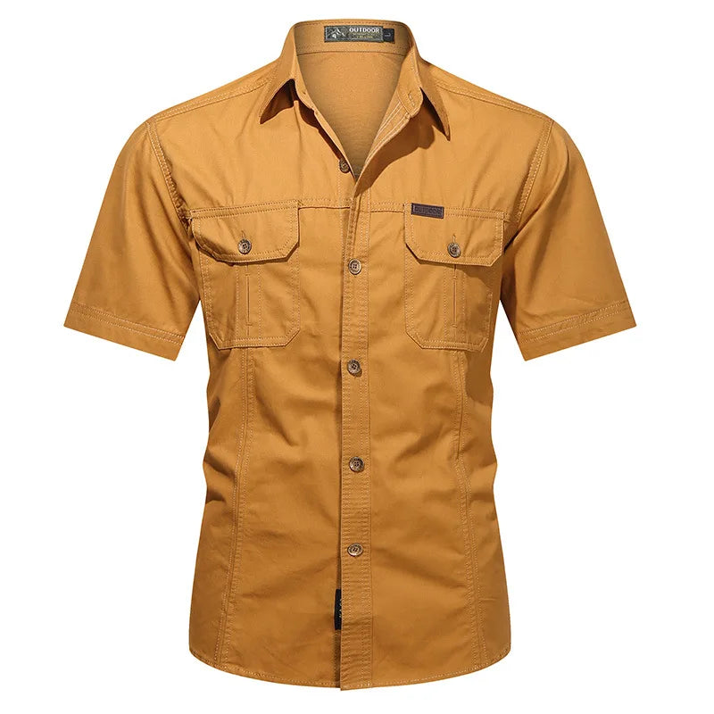 The Men’s Quick-Dry Tactical Shirt by Ten Essentials is a brown, short-sleeve button-up with a military-inspired design, featuring two chest pockets and a collar, shown on a white background.