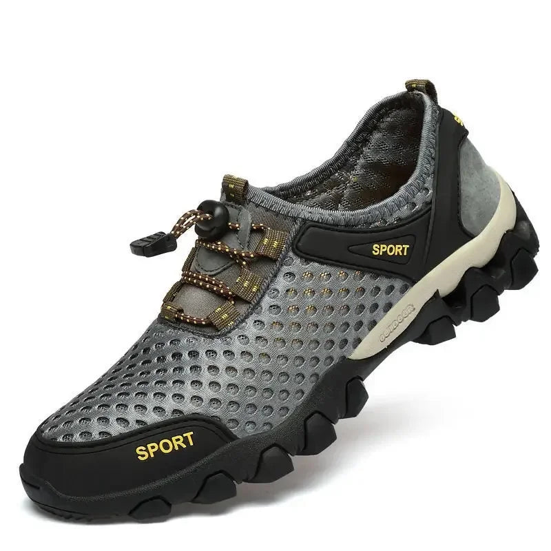 Introducing Ten Essentials’ Men’s Breathable Mesh Sneakers: lightweight grey shoes perfect for hiking, with a non-slip rubber sole and breathable mesh. They feature yellow SPORT labels, drawstring laces, and a padded interior for comfort.
