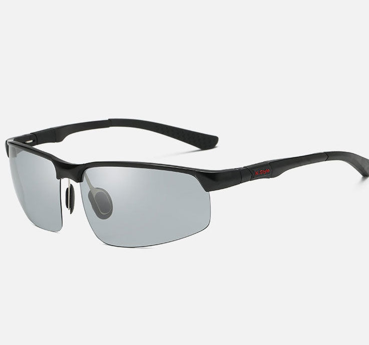 The eprolo Mens Photochromic Sunglasses offer a sleek, modern look with a matte black frame and mirrored lenses. Featuring polarized protection for HD vision and a small red temple detail, these semi-rimless sunglasses have adjustable nose pads for added comfort and style.