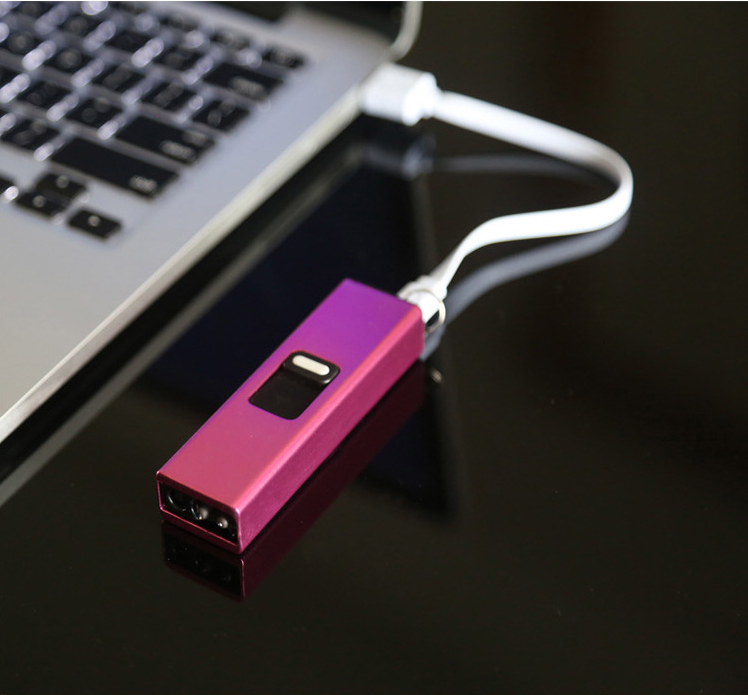 A purple and pink Telescopic Pulse Arc Lighter with LED Flashlight by eprolo is USB-recharged and linked to a laptop using a white cable on a glossy black surface, with the laptops keyboard partially visible in the background for a sleek setup.