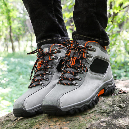 In a forested area, someone stands on a rock wearing My Store’s Breathable Waterproof Hiking Sneakers with anti-slip soles and orange-black laces. Black pants peek out amid lush greenery, promising an adventurous journey with every step.
