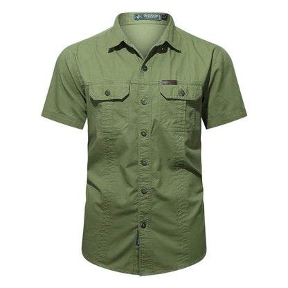 The Men’s Quick-Dry Tactical Shirt by Ten Essentials is a green, military-inspired short-sleeved shirt with two buttoned flap chest pockets, crafted from breathable cotton fabric and featuring a collar with a subtle logo tag above the left pocket.