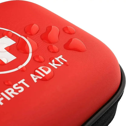 Close-up of the red Ten Essentials Portable First Aid Kit, adorned with a white medical cross and FIRST AID KIT text, water droplets visible on its surface. Ideal for emergencies, it features a zipper at the bottom edge.
