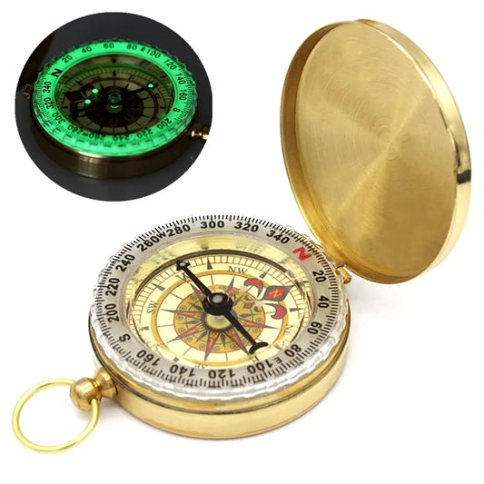 The Ten Essentials Portable Water-Resistant Luminous Brass Compass features an open lid revealing a detailed cardinal direction dial, ideal for outdoor adventures and survival situations. It glows green in the dark, and a ring is attached for easy hanging or carrying.
