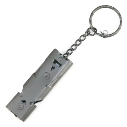 The Ten Essentials High-Decibel Double Pipe Survival Whistle is a portable emergency keychain with a black rectangular body, circular ring, and durable construction. Featuring visible screws and a grooved design, it doubles as an emergency signaling tool for added safety.