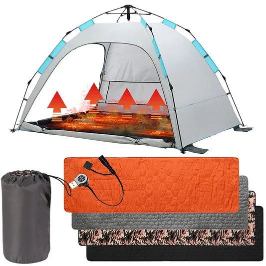 A light gray pop-up tent with heat emissive panels sits nearby. Below, three folded cushioned mats in orange, gray, and camouflage are next to a compact gray carrying bag. On top is the Ten Essentials USB Heated Sleeping Bag Pad, ensuring comfort and warmth on chilly nights.