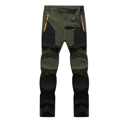 Ten Essentials olive green and black Men’s Quick-Dry Hiking Pants feature orange zippers, reinforced knees, and multiple pockets. Made with water-resistant stretch fabric, they provide UV protection for safety outdoors.