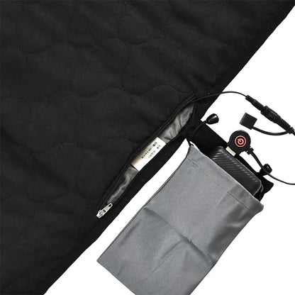 Close-up of the black quilted USB Heated Sleeping Bag Pad by Ten Essentials shows a partially open zipper with an inner label. A gray pocket holds a control device connected by wires, featuring black buttons for adjustable 3-level temperature on this fast-heating camping mat.
