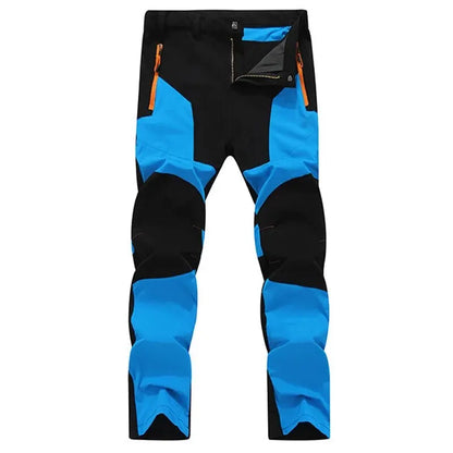 Ten Essentials Men’s Quick-Dry Hiking Pants feature UV protection and water-resistant, ultra-stretch fabric. Available in black and blue with orange zippered pockets, they boast reinforced knees and a slim fit for enhanced comfort during any adventure.