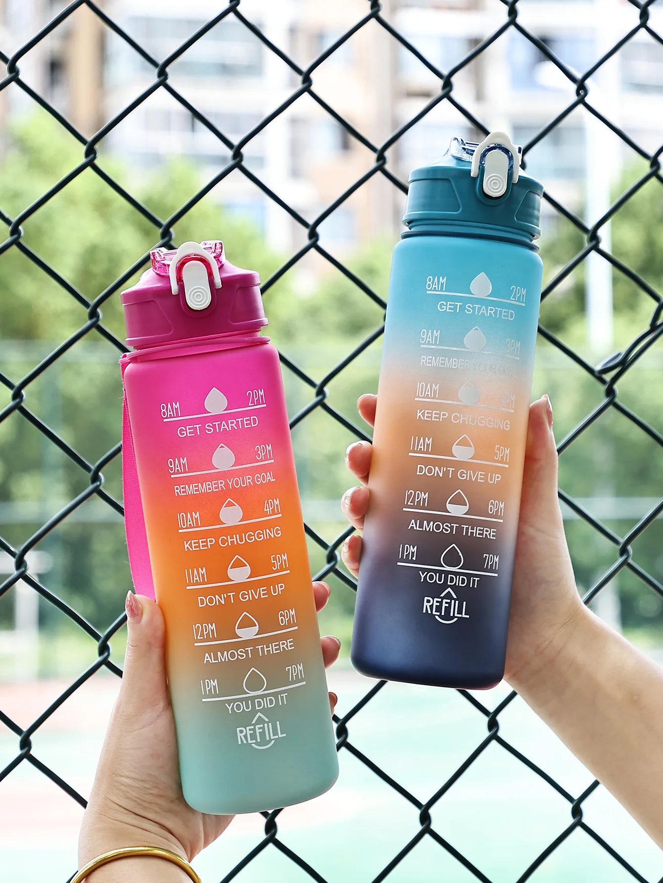 Two vibrant Ten Essentials Sports Water Bottles, showcasing time markers from 8 AM to 7 PM and motivational quotes like Keep Chugging and You Did It, feature eye-catching gradient designs in pink-orange and blue-gray to brighten your daily hydration routine.