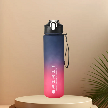 A Ten Essentials Sports Water Bottle (750-800ML) with a navy-to-pink gradient sits on a round beige pedestal. It features a black lid with white flip-top and loop. SPIRIT is printed in white, adding motivation. A green palm leaf provides the backdrop.