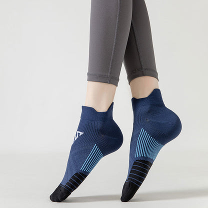 A person showcases the grip and design of Modalysts blue and black compression sports socks, featuring moisture-wicking, anti-blister protection, while wearing gray leggings against a plain white background.